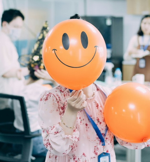 Person holding smiley balloon